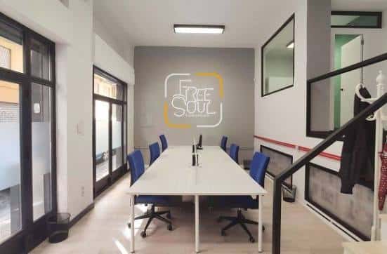 Sala de reuniones con mesa larga y logo 'Free Soul' en la pared