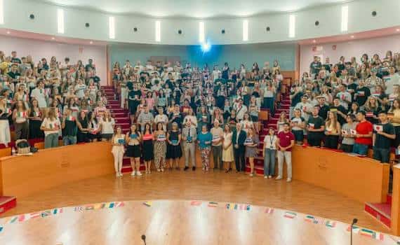 Grupo de estudiantes posando en el escenario del auditorio