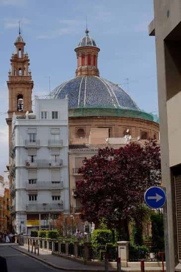 Fachada lateral de la iglesia con cúpula y entorno urbano