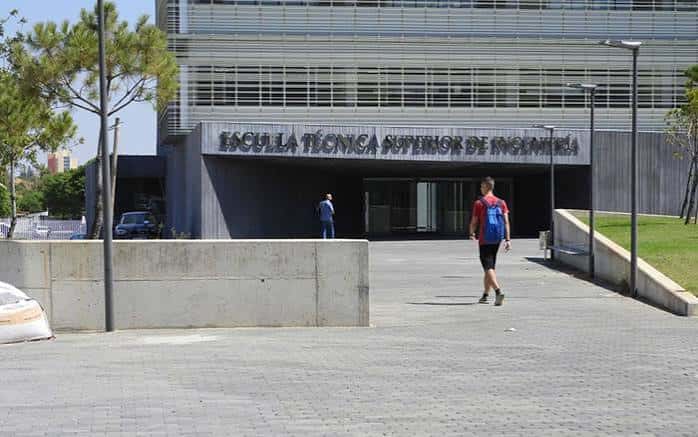 Fachada moderna de la ETSI con estudiantes caminando frente al edificio