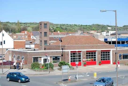 Vista exterior del Cosham Fire Station con fachada de ladrillo y puertas rojas