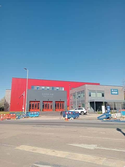 Entrada principal del Cosham Fire Station con edificio rojo y señalización clara