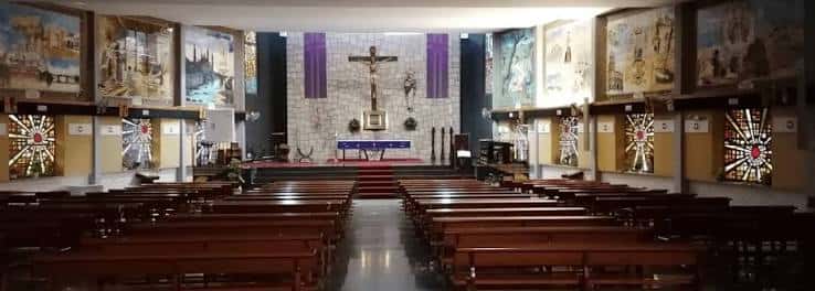 Vista panorámica del interior de la parroquia mostrando el altar y los bancos