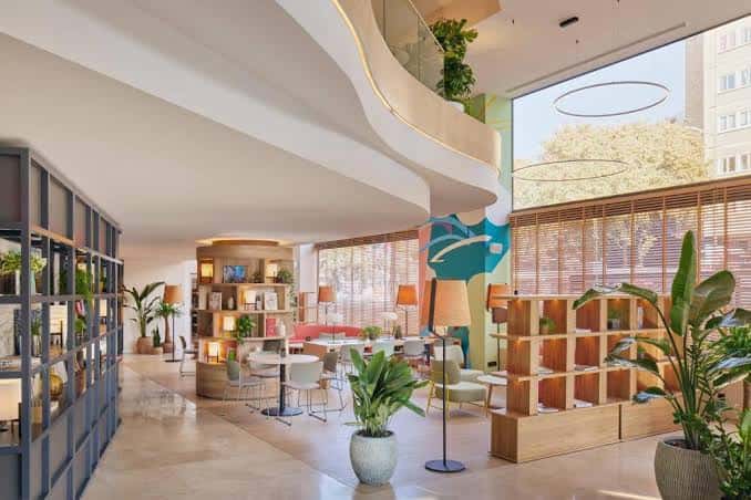 Interior moderno y acogedor del lobby con estanterías de madera y plantas
