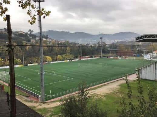 Vista panorámica del Campo Municipal de Oira con césped artificial y gradas bajo cielo nublado
