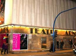 Entrada nocturna del Teatro Arniches con iluminación y carteles publicitarios