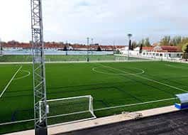 Campo de fútbol completo con porterías y estructura metálica lateral