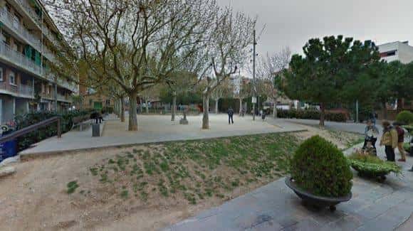 Plaza abierta con zonas verdes y personas caminando