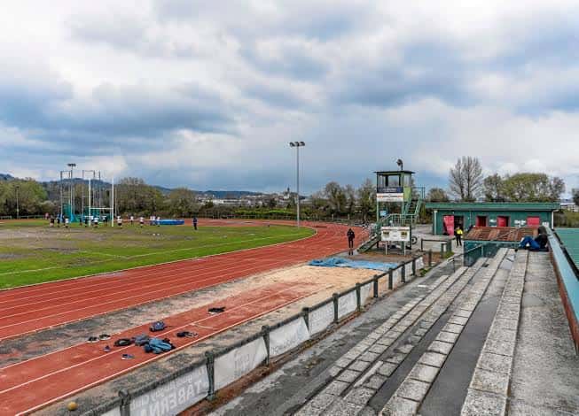 Vista general del complejo deportivo con gradas y pista de atletismo