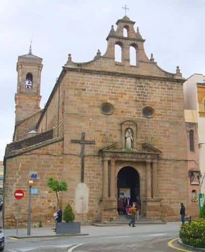 Vista exterior de la Iglesia de San Francisco de Asís en Linares, mostrando su fachada principal de piedra con cruz y entrada