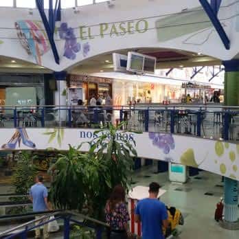 Vista interior del Centro Comercial El Paseo con decoración floral y personas caminando