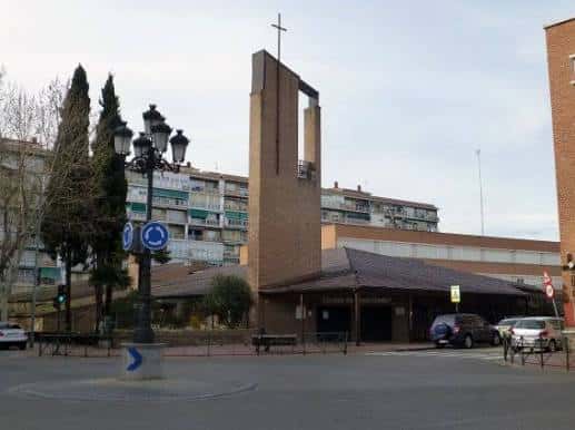 Fachada principal de la parroquia bajo cielo nublado, mostrando el campanario y entrada accesible