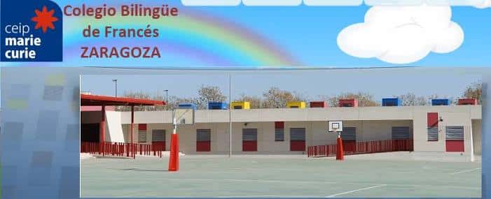 Vista exterior del patio deportivo del CEIP Marie Curie con canastas y fachada moderna