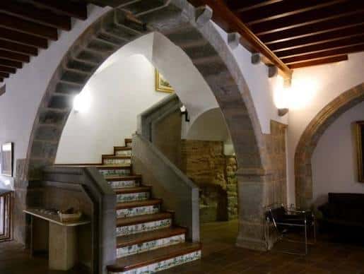 Escalera interior con arcos de piedra y detalles arquitectónicos históricos