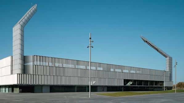 Vista exterior del Estadio Nueva Balastera con su distintiva arquitectura moderna y torres inclinadas bajo cielo despejado