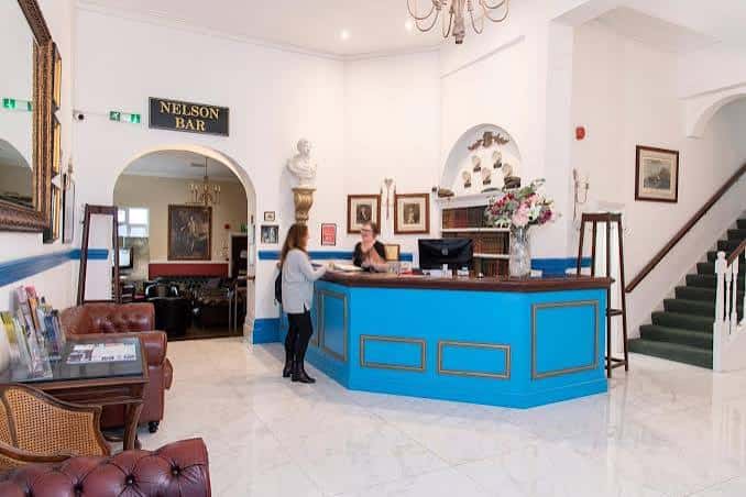 Recepción del hotel con mostrador azul y decoración clásica