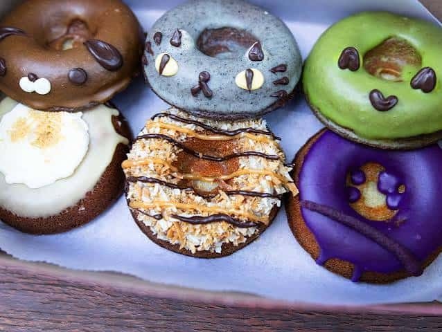 Selección de donuts decorados con diseños temáticos como gatos y corazones