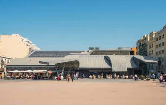 Vista exterior del Mercado de la Barceloneta con su distintiva arquitectura moderna bajo un cielo despejado