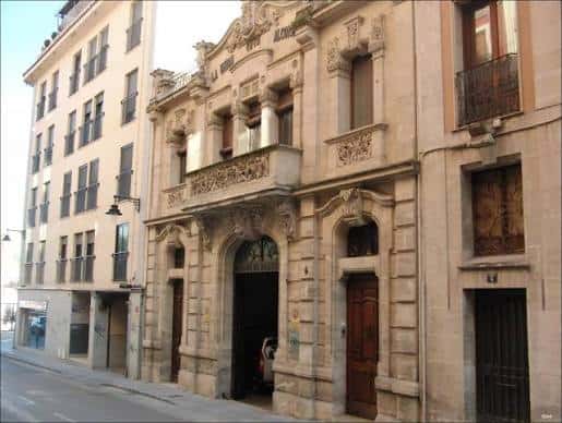 Vista lateral del edificio histórico mostrando su fachada ornamental y entorno urbano