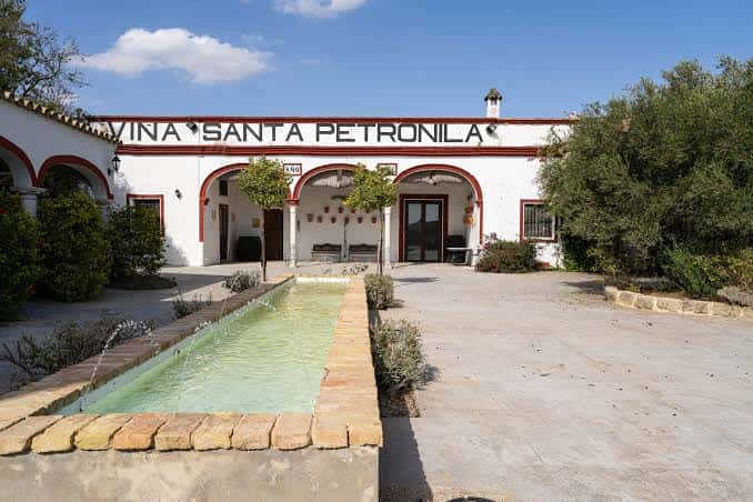 Fachada principal de la Bodega Viña Santa Petronila con fuente y jardines