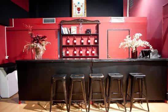Bar interior con paredes rojas y estantería de botellas