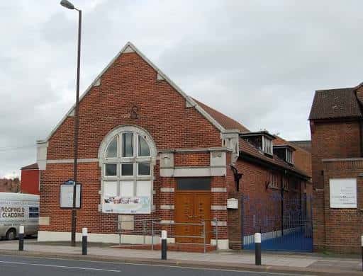 Vista exterior del Christ Church Hall en Portsmouth, edificio de ladrillo rojo con entrada principal y rampa de acceso