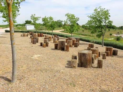 Área de descanso con troncos de madera en el Parque de las Contiendas