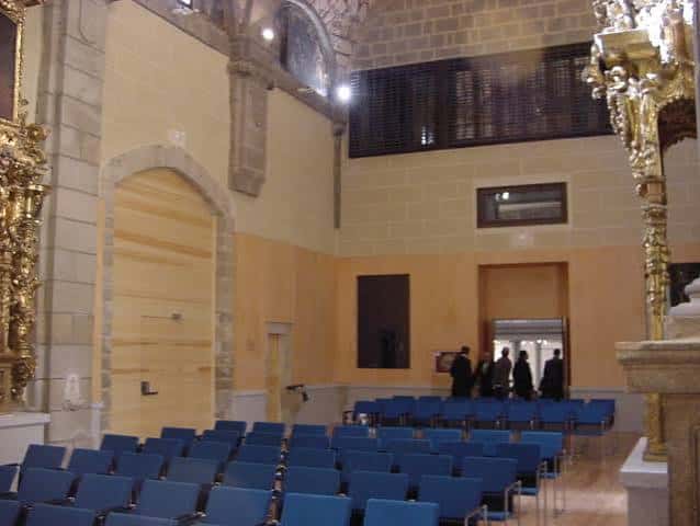 Interior del auditorio con butacas azules y detalles arquitectónicos históricos