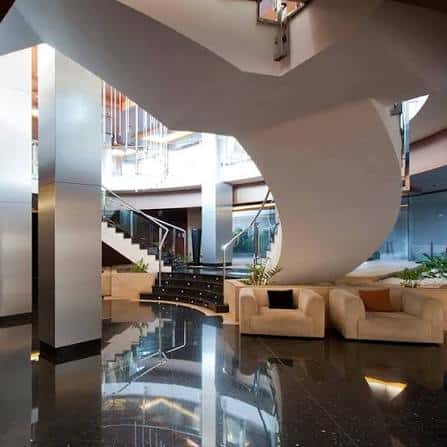 Lobby moderno del hotel con escalera curva y sofás de diseño