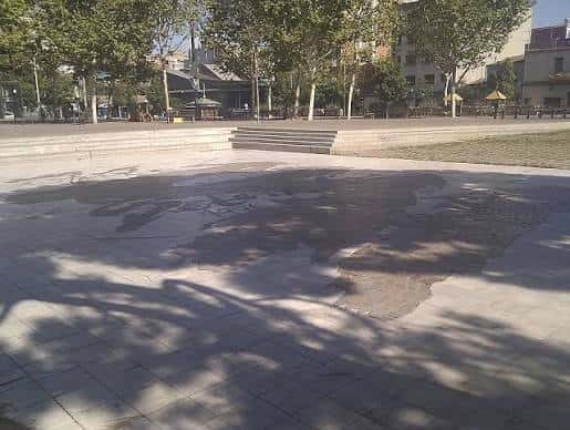 Vista general de la Plaça de Catalunya con el mosaico del mapa en primer plano y árboles alrededor