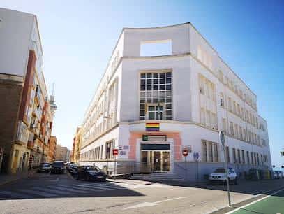 Fachada principal del IES Columela en Cádiz con arquitectura moderna y banderas