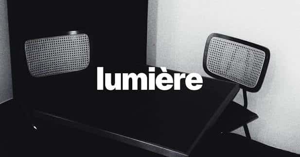 Escena minimalista en blanco y negro con el nombre 'lumière' sobre una mesa y sillas