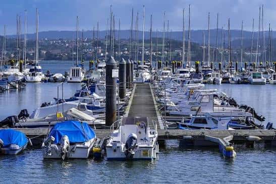 Muelle central del puerto deportivo con veleros y lanchas organizadas en filas
