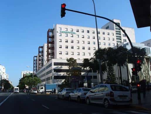 Vista exterior del Hospital Universitario Puerta del Mar desde la calle con tráfico y semáforos