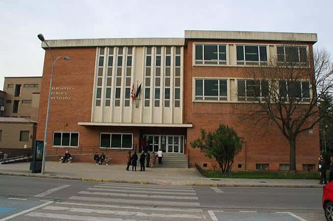 Vista frontal del edificio con entrada principal y banderas municipales