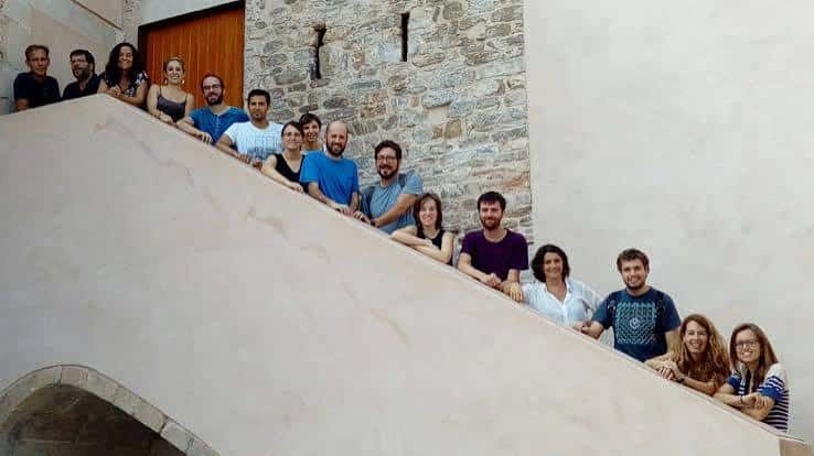 Interior del edificio mostrando una escalera moderna y un grupo de personas en el espacio común