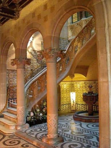 Interior del vestíbulo con escalera de mármol y arcos decorativos