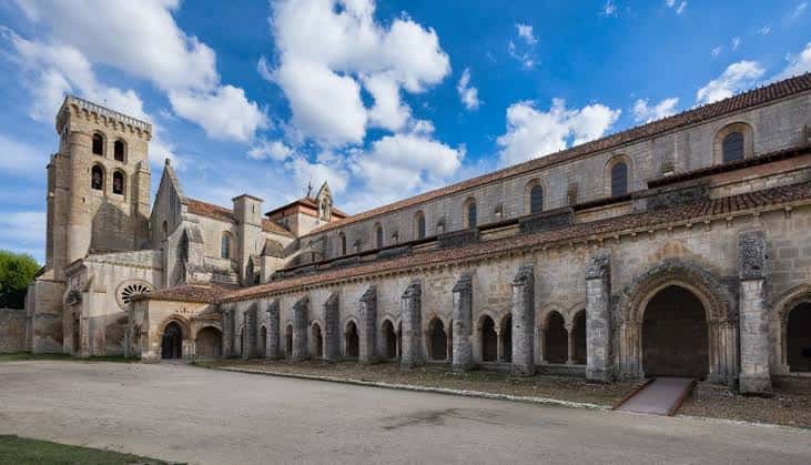 Vista panorámica del claustro románico bajo cielo azul
