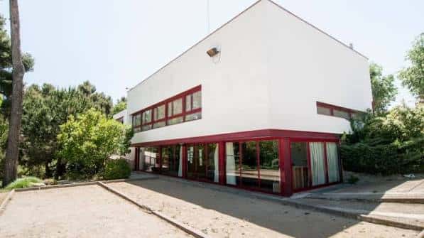 Vista exterior del Casal Les Planes con fachada blanca y detalles en rojo