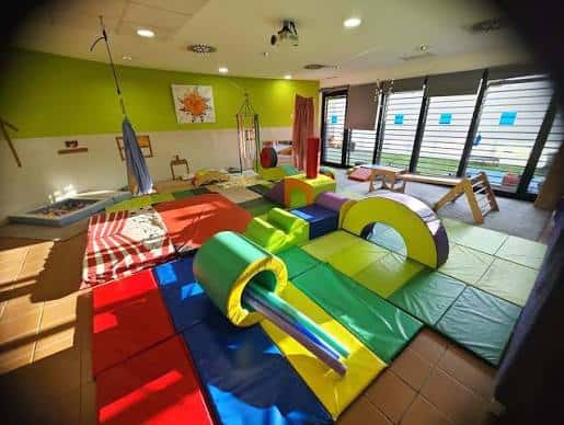 Sala de psicomotricidad con colchonetas y material deportivo