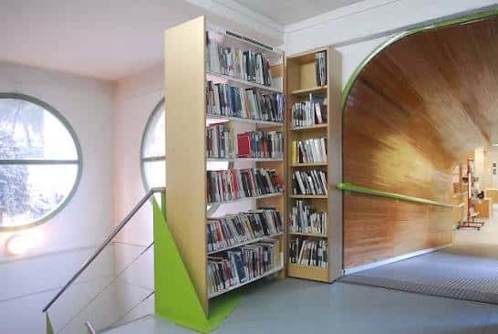 Interior moderno de la biblioteca con estanterías y túnel de madera