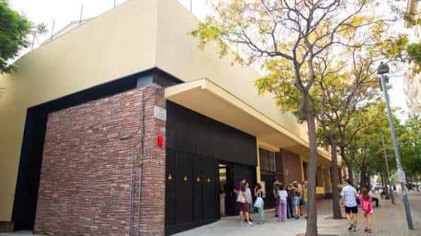 Fachada exterior del centro juvenil Joves de les Corts con personas entrando