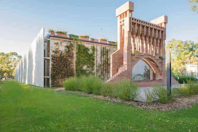 Fachada arquitectónica moderna con estructura de ladrillo y vegetación integrada
