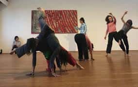 Bailarines practicando coreografía grupal en el estudio de danza