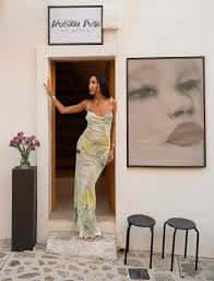 Mujer posando en la entrada de la galería junto a una gran obra de arte