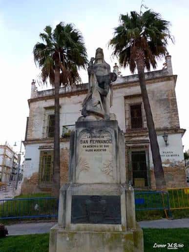 Estatua en el centro de la plaza frente al edificio colonial