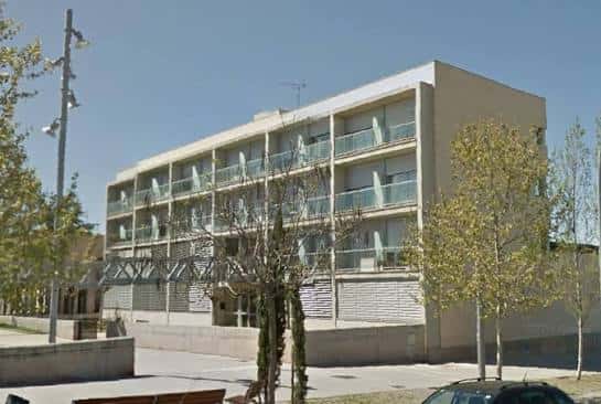 Fachada lateral del centro comunitario con balcones y entorno arbolado en Manresa