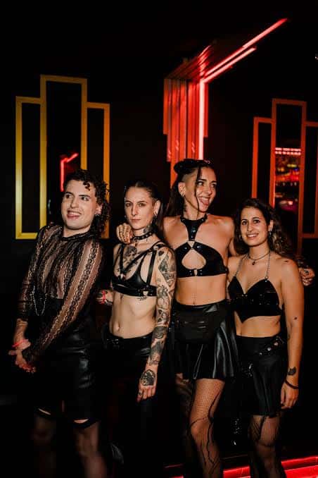Grupo de personas en el interior del club con iluminación roja y decoraciones art deco