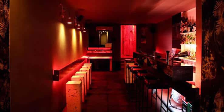 Vista interior del bar del club con barra y estantería de bebidas