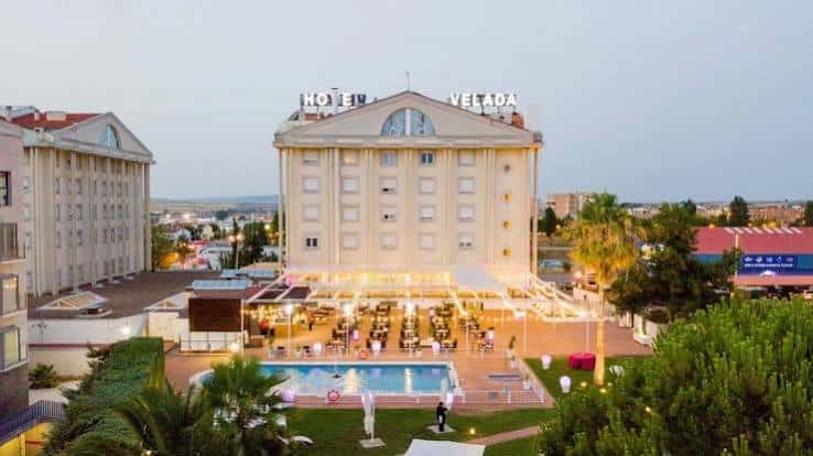 Vista exterior del Hotel Velada Mérida con piscina y zona de eventos al atardecer